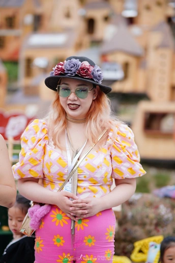 一位戴着花帽子、太阳镜参加节日的女士