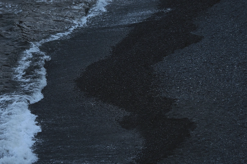 夜晚的海滩上有沙滩上的暗影和海洋中的暗水