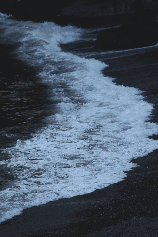 夜晚的海滩 黑色沙粒和波浪