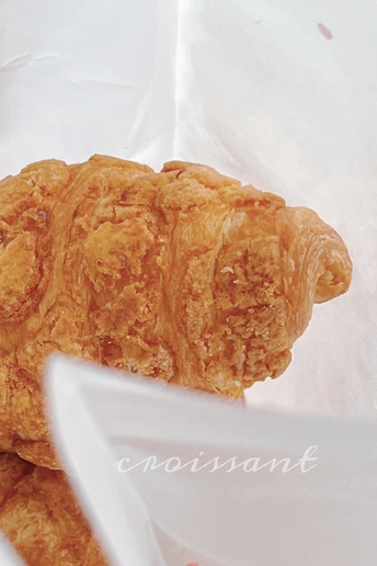 白色纸袋上塑料容器里的羊角面包