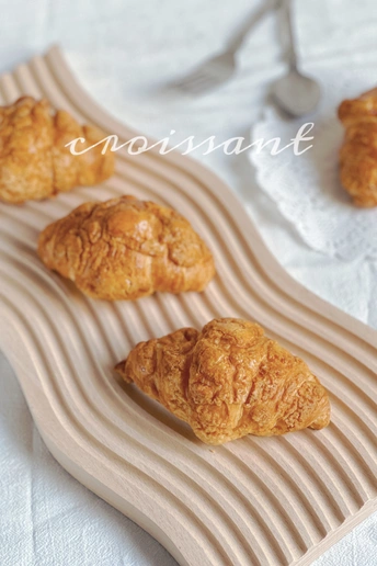 放在盘子上的一些羊角面包和其他糕点