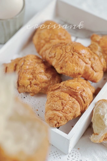 装满饼干、羊角面包和一些牛奶的白色托盘