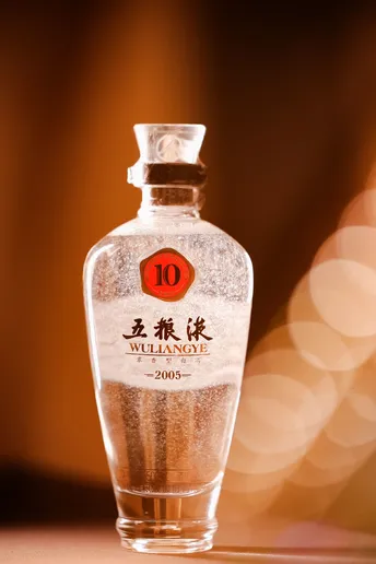 一瓶水在桌子上 前面有一盏灯
