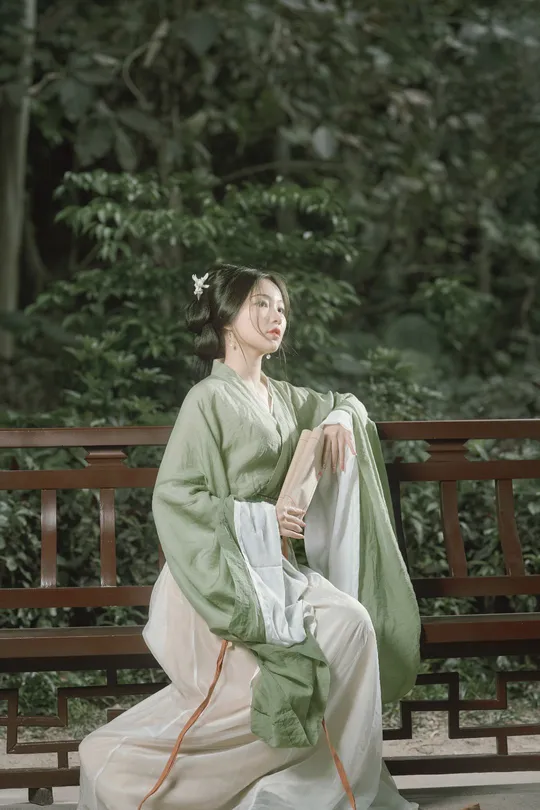 一位穿着传统服装的年轻女子坐在长凳上