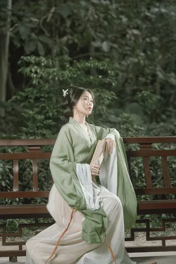 一位穿着传统服装的年轻女子坐在长凳上