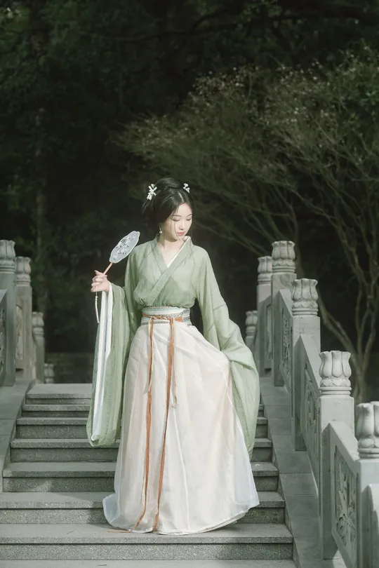 一位穿着传统绿色和服的女人走下楼梯