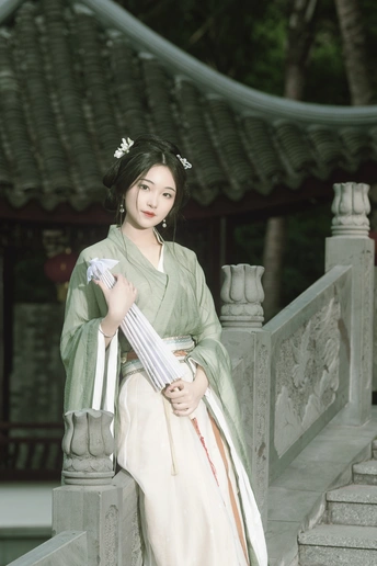 一位穿着和服的年轻女子手持雨伞站在寺庙前