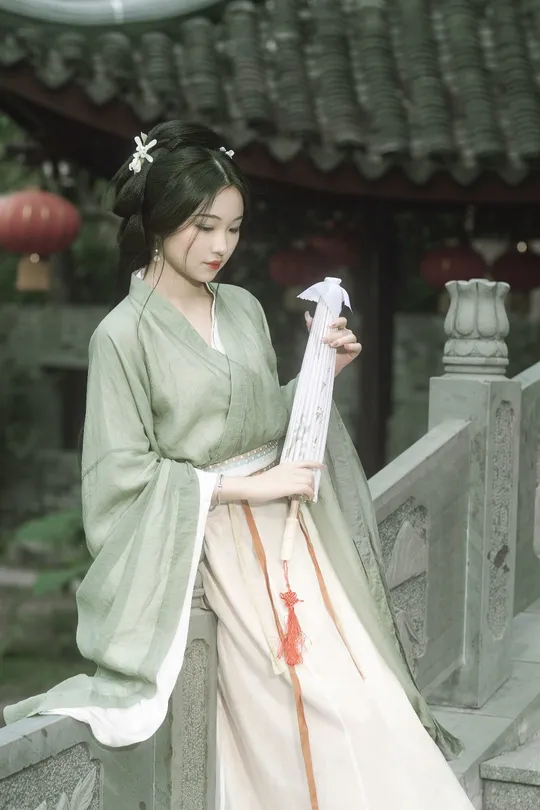 一位穿着和服的年轻女子拿着雨伞