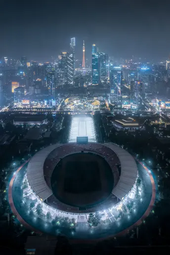 夜晚的体育场与城市背景相辉映