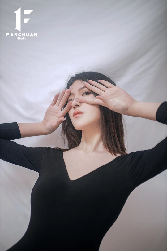 一位身穿黑白连衣裙的年轻女子双手捂着眼睛 掩面