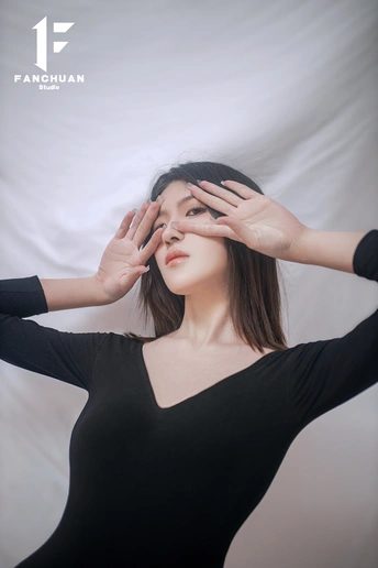 一位身穿黑白连衣裙的年轻女子双手捂着眼睛 掩面