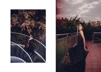 一位穿着黑色连衣裙的女人站在桥上的一张照片