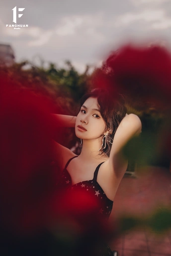 一位穿着红裙子的年轻女子在为拍照