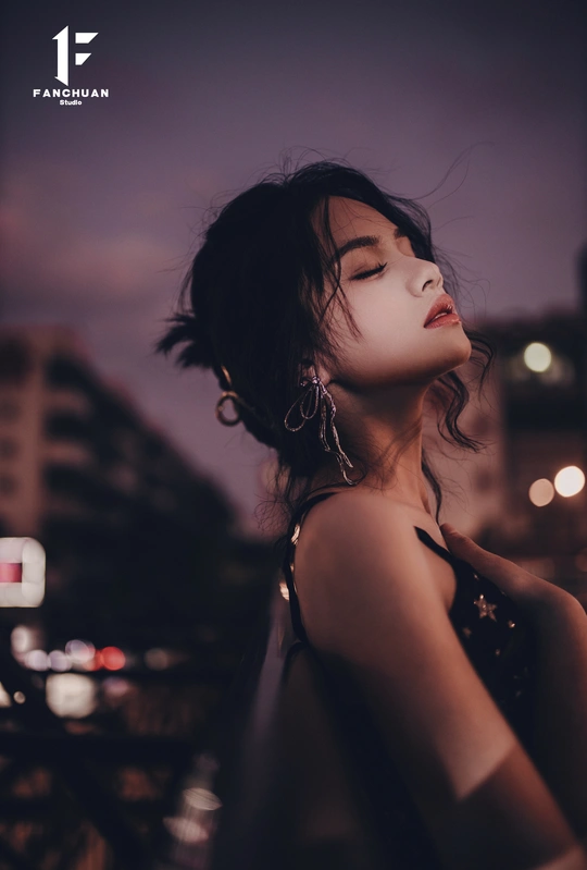 一位年轻女子夜晚站在屋顶上闭着眼睛