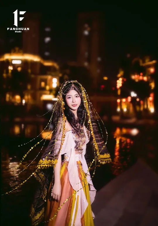 一位穿着传统服装的年轻女士在夜晚的河边