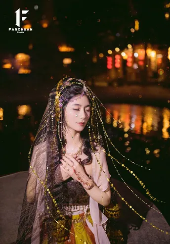 夜晚在水边的一个美丽的女孩穿着服装