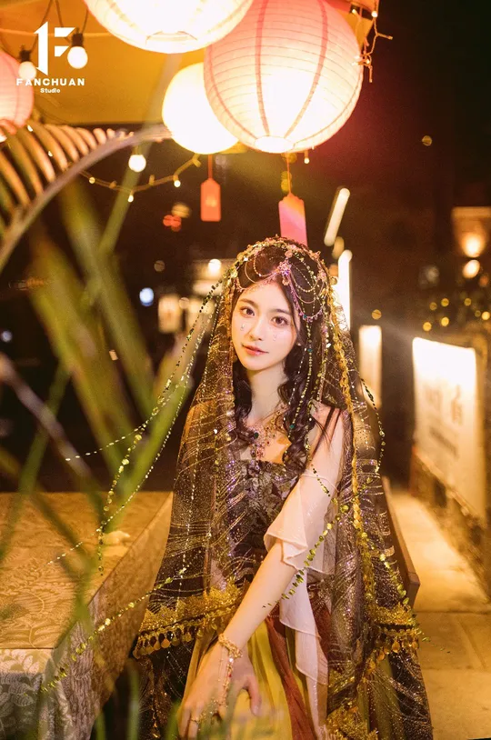 一位美丽的年轻女士穿着传统服装参加夜晚的人节庆祝活动。