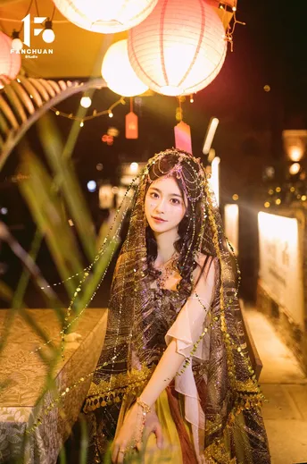 一位美丽的年轻女士穿着传统服装参加夜晚的人节庆祝活动。