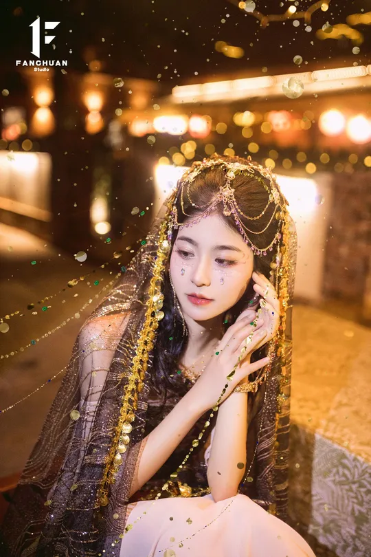 一个穿着打扮成人的女人 背景有灯光。