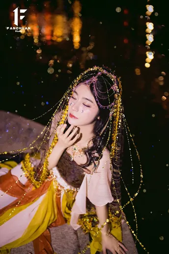 一位穿着晚礼服的年轻女士在水边夜晚