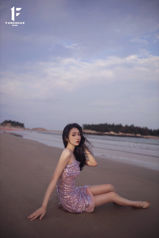 一位年轻女子坐在沙滩上