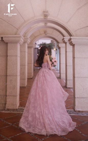 一位穿着粉红色婚纱 拖尾长裙的美丽女士