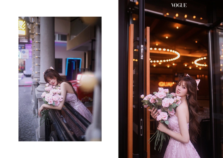 一位穿着粉红色连衣裙的年轻女子 手里拿着一束花 站在窗户前。