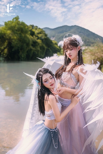 美丽的女孩们穿着白色的服装在水边