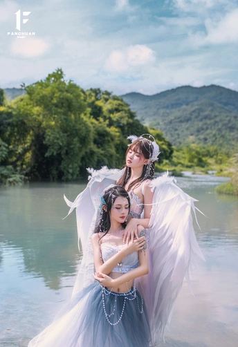 美丽的女子身着天使装 翅膀在湖水中