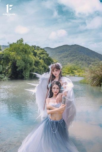 一位穿着天使装的美丽女子在水中的蓝色水域