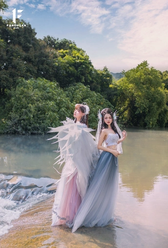 一位穿着长袍的美女站在水中