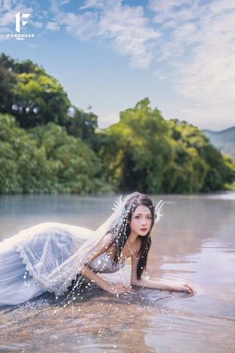 一位穿着白色婚纱的美女在水中的画面