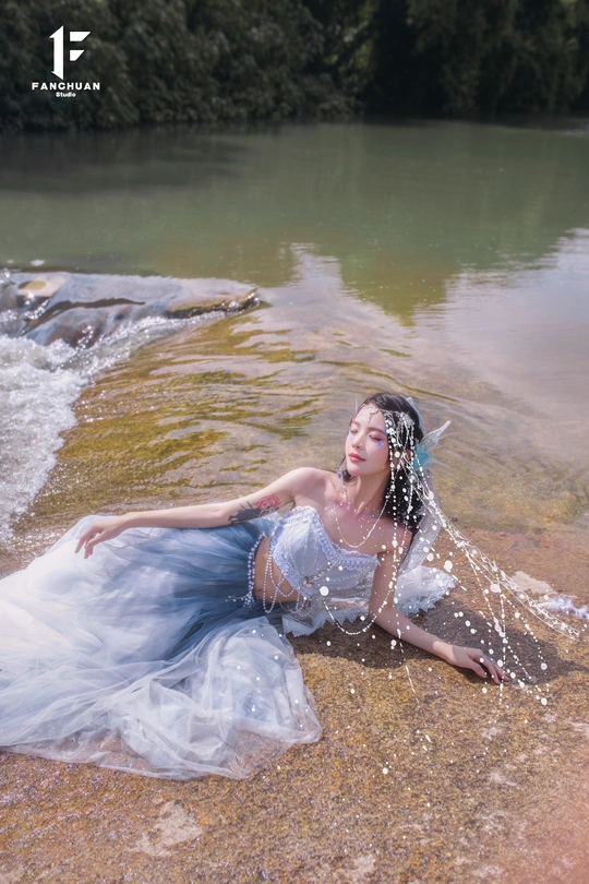 一位穿着蓝色连衣裙的美女在水边