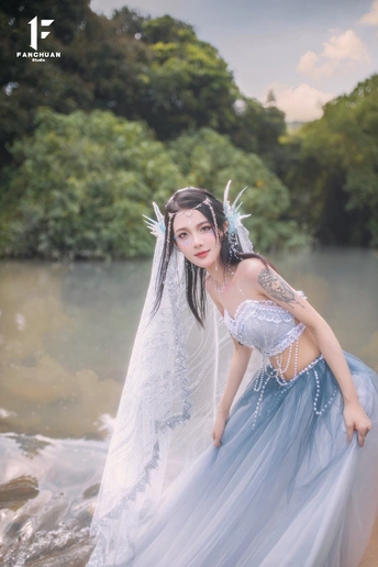 一位穿着白色婚纱的美女正在河水中漫步。