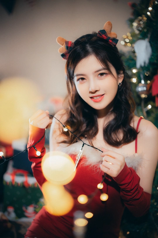 一位穿着西方基督教节日的年轻女子手持点燃的蜡烛 