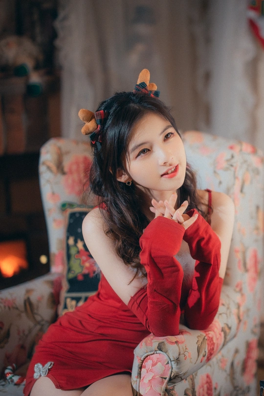 一位穿着红色连衣裙和红色长筒袜的年轻女子坐在红色椅子上