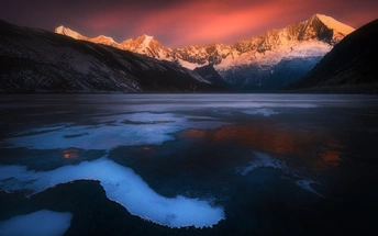 山脉在湖中倒影 太阳照亮天空