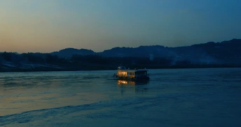 夕阳西下时 一艘小船漂浮在一大片水上。