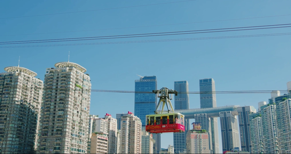 空中飞行的红色缆车在城市高楼上空