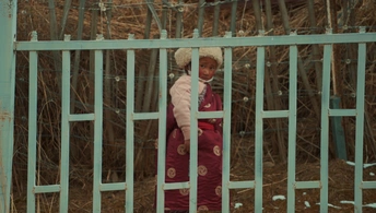 一位妇女和一名儿童站在一扇门后面