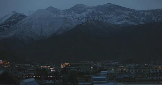 夜晚的城市和背景中的山脉