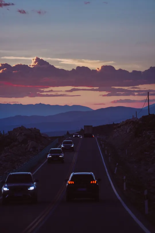 夕阳西下 山峦间高速公路上的汽车飞驰而过。