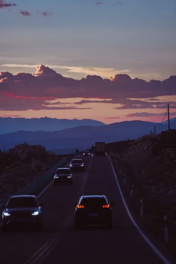 夕阳西下 山峦间高速公路上的汽车飞驰而过。