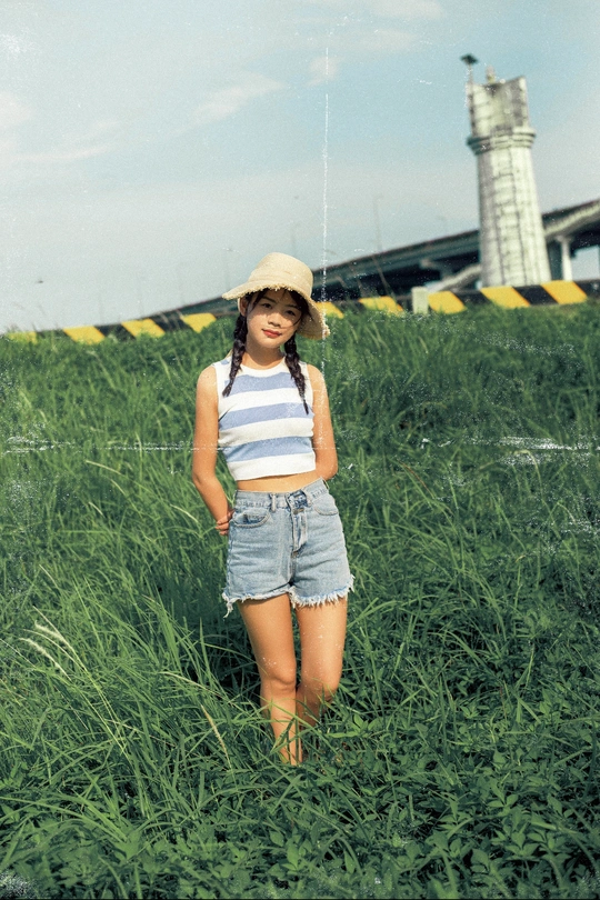 一个小女孩站在一片高草地上