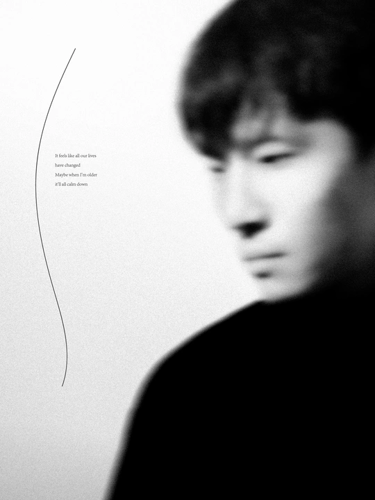 一张黑白照片 一个年轻男子正在看一件艺术品。