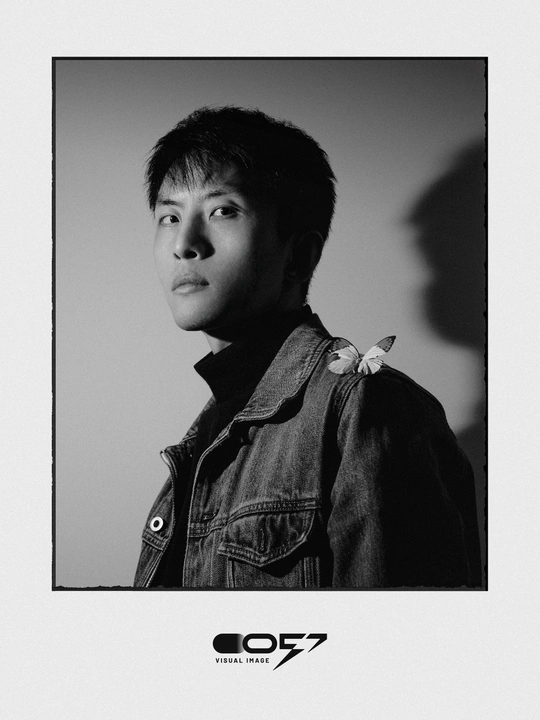 一张黑白照片 一个年轻男子穿着牛仔裤夹克在室内拍照