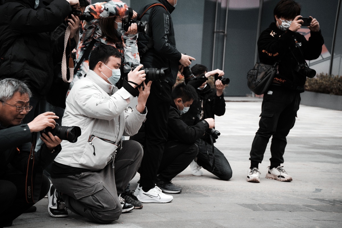 一个男人用相机给一群人拍照