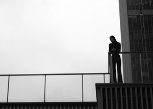 一男一女站在背景是高楼大厦的桥上
