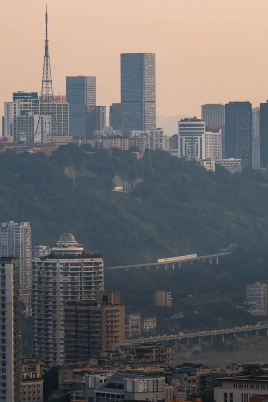 一座拥有高楼大厦和背景中的山和山脉的大型城市。