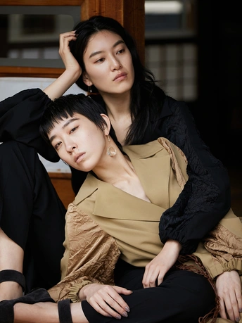 坐在一名年轻男子旁边摆姿势的一名年轻女子